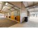 Barn with multiple stalls, wood paneling, brick flooring, and overhead lighting at 5700 S University Blvd, Greenwood Village, CO 80121