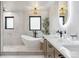 Bright bathroom with a free standing tub, decorative lighting, and neutral tile at 5700 S University Blvd, Greenwood Village, CO 80121