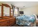 Cozy bedroom featuring a dresser with mirrors, a window, and a television at 17703 E Nassau Pl, Aurora, CO 80013