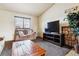 Cozy living room with a stone fireplace, comfortable seating, and natural light from a window at 17703 E Nassau Pl, Aurora, CO 80013