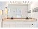 Bathroom features double sinks, granite countertops, a large mirror, and modern fixtures at 577 Tristan Pl, Berthoud, CO 80513
