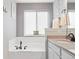 Elegant bathroom with soaking tub, white subway tile, granite countertop, and bronze fixtures at 577 Tristan Pl, Berthoud, CO 80513