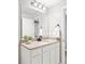 Bright bathroom featuring a large mirror, granite countertops, white cabinets, and modern fixtures at 577 Tristan Pl, Berthoud, CO 80513
