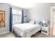 Cozy bedroom features a comfortable bed, large window with blue curtains, and gray walls at 577 Tristan Pl, Berthoud, CO 80513