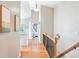 Inviting hallway with hardwood floors, decorative railing, and views to living spaces at 577 Tristan Pl, Berthoud, CO 80513