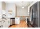 Well-lit kitchen with stainless steel appliances, granite counters, and hardwood floors at 577 Tristan Pl, Berthoud, CO 80513