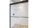 Modern shower featuring sleek tile walls, pebble floor, and a contemporary black frame sliding door at 577 Tristan Pl, Berthoud, CO 80513
