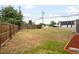 The backyard is spacious with a mix of grass and mulch, enclosed by a wood fence at 7600 Kearney Dr, Commerce City, CO 80022