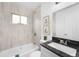 Updated bathroom featuring a tiled shower, granite countertop, and modern fixtures at 7600 Kearney Dr, Commerce City, CO 80022