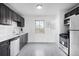 Updated kitchen with stainless steel appliances, white subway tile, and dark cabinetry at 7600 Kearney Dr, Commerce City, CO 80022