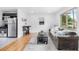 Bright living room with hardwood floors, large window, and modern furniture at 7600 Kearney Dr, Commerce City, CO 80022