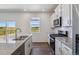 Modern kitchen with white cabinets, granite countertops, stainless steel appliances, and view to the exterior at 1836 Westport Ave, Berthoud, CO 80513