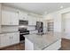 Modern kitchen with white cabinets, granite countertops, stainless steel appliances, and center island at 1836 Westport Ave, Berthoud, CO 80513