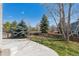 Large, fenced backyard with a concrete patio and mature trees on a sunny day at 10806 Crooke Dr, Parker, CO 80134
