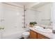 Bright bathroom features a bathtub with shower, built-in shelving, and vanity sink at 10806 Crooke Dr, Parker, CO 80134