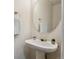 Bright half-bathroom featuring a pedestal sink and a decorative round mirror at 10806 Crooke Dr, Parker, CO 80134