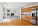 Open floor plan with wood floors, fireplace, and kitchen with stainless steel refrigerator at 10806 Crooke Dr, Parker, CO 80134
