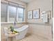 Relaxing bathroom with soaking tub, tiled walls, and modern fixtures at 7036 E Archer Pl, Denver, CO 80230