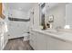 Modern bathroom with double vanity, walk-in shower, and grey tile floors at 7036 E Archer Pl, Denver, CO 80230