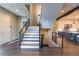 Modern staircase with metal railing, leading to an open kitchen area at 7036 E Archer Pl, Denver, CO 80230