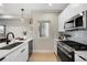 Modern kitchen features stainless steel appliances, sleek white cabinetry, and light hardwood floors at 1473 N Locust St, Denver, CO 80220