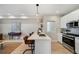 Open-concept kitchen with a breakfast bar, stainless steel appliances, and quartz countertops at 1473 N Locust St, Denver, CO 80220
