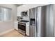 Modern kitchen with stainless steel appliances, white cabinets, and marble backsplash at 1473 N Locust St, Denver, CO 80220
