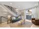 Bright living room featuring a modern staircase, sofa, and access to a balcony at 1473 N Locust St, Denver, CO 80220