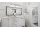 Bright bathroom featuring a double vanity, framed mirror, and a shower-over-tub at 8615 W Berry Ave # 203, Littleton, CO 80123