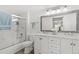 Bright bathroom featuring a double vanity, framed mirror, and a shower-over-tub at 8615 W Berry Ave # 203, Littleton, CO 80123