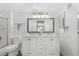 Bright bathroom featuring a double vanity, framed mirror, and a shower-over-tub at 8615 W Berry Ave # 203, Littleton, CO 80123