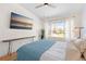 Serene bedroom with a large window, mounted TV, wooden desk, and natural light at 8615 W Berry Ave # 203, Littleton, CO 80123