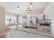 Modern kitchen with marble countertops, stainless steel appliances, and adjacent dining area at 8615 W Berry Ave # 203, Littleton, CO 80123