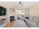 Comfortable living room featuring a fireplace, built-in shelves, a ceiling fan, and access to a private balcony at 8615 W Berry Ave # 203, Littleton, CO 80123