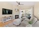 Comfortable living room featuring a fireplace, built-in shelves, a ceiling fan, and access to a private balcony at 8615 W Berry Ave # 203, Littleton, CO 80123
