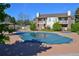 Community pool with a cover surrounded by a fence, gazebos, mature trees, and beautiful buildings at 8615 W Berry Ave # 203, Littleton, CO 80123
