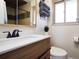Bright bathroom featuring a modern vanity, neutral tones, and a well-lit shower with stylish tile accents at 9787 W Ohio Ave, Lakewood, CO 80226