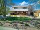 Lovely exterior view with a well-manicured lawn, mature trees, and a charming front porch at 9787 W Ohio Ave, Lakewood, CO 80226