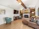 Comfortable living room showcasing a fireplace, built-in shelves, and wood flooring at 9787 W Ohio Ave, Lakewood, CO 80226