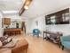 Open-concept living area featuring wood floors, a large TV, and an adjacent kitchen area at 9787 W Ohio Ave, Lakewood, CO 80226