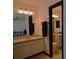 Bathroom featuring double sink vanity and a mirror, with tile flooring and dark trim details at 21518 E Powers Ln, Centennial, CO 80015