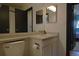 Standard bathroom featuring a sink, toilet, and mirror and view into another room at 21518 E Powers Ln, Centennial, CO 80015