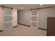 Room featuring sliding barn doors, neutral carpet, and paint at 21518 E Powers Ln, Centennial, CO 80015