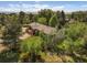 Brick home aerial view showcases a wooden deck and picturesque, verdant surroundings at 5460 S Olive St, Greenwood Village, CO 80111