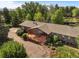 Aerial view of a brick house surrounded by lush greenery and a wooden deck at 5460 S Olive St, Greenwood Village, CO 80111