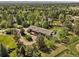 Aerial view: a brick home, a wooden deck, and stunning tree coverage at 5460 S Olive St, Greenwood Village, CO 80111