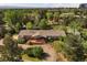 Spacious brick home with a large wooden deck, nestled among mature trees at 5460 S Olive St, Greenwood Village, CO 80111