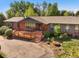 Beautiful brick house featuring a spacious wooden deck and well-maintained landscaping at 5460 S Olive St, Greenwood Village, CO 80111