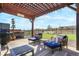 Covered outdoor lounge area, grill, hot tub, and artificial turf create an inviting outdoor space at 15776 Native Willow Dr, Monument, CO 80132