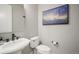 Stylish bathroom featuring pedestal sink, toilet, and tasteful artwork at 15776 Native Willow Dr, Monument, CO 80132